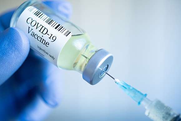 Profissional de saúde manipula uma seringa de vacina