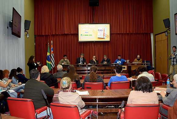 Auditorio da Assembleia Legislativa de São Paulo com público sentado nas cadeiras de costas e uma mesa de bate com participantes de frente para a foto