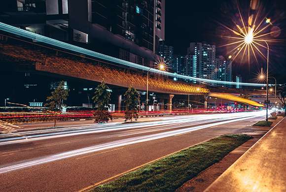 Foto mostra uma avenida durante a noite sem carros